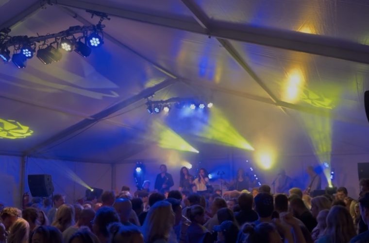 Live swingband treedt op tijdens het avondevenement Swing op de Brink in Muiderberg, met toeschouwers die genieten van de muziek op de dorpspleats