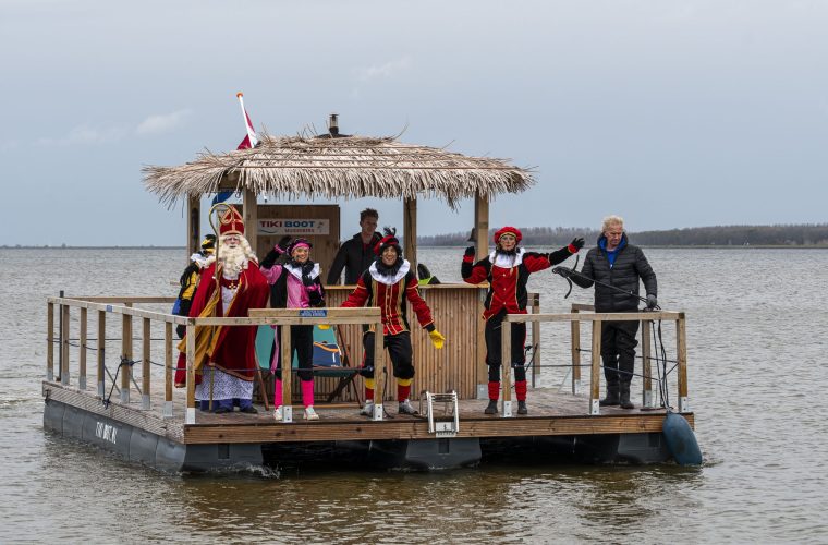 Sinterklaas en zijn Pieten arriveren op De Brink in Muiderberg tijdens de jaarlijkse intocht, kinderen en ouders wachten vol verwachting
